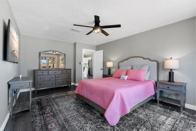 bedroom featuring freestanding refrigerator, wood finished floors, visible vents, and baseboards