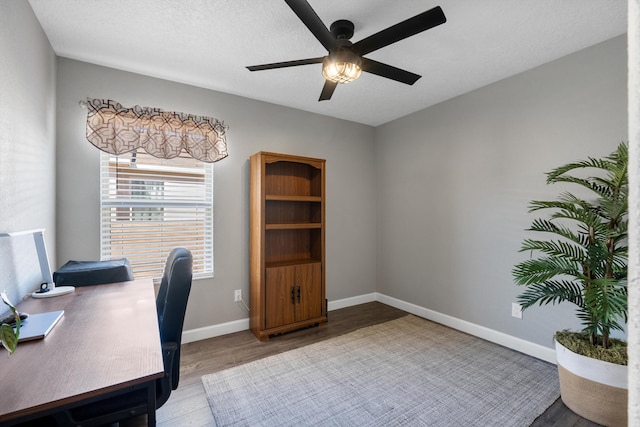 office with baseboards, ceiling fan, a textured ceiling, and light wood-style floors