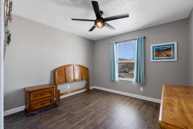 bedroom featuring ceiling fan, baseboards, dark wood finished floors, and a textured ceiling