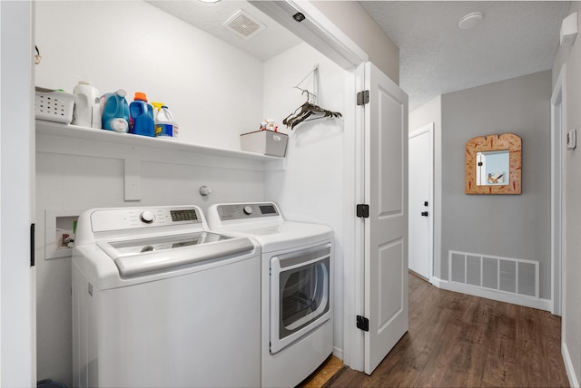 laundry area featuring laundry area, dark wood-type flooring, washing machine and dryer, and visible vents