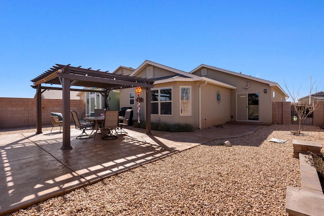 back of property with stucco siding, a fenced backyard, a pergola, and a patio