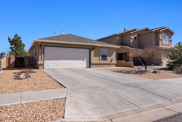 view of front of house featuring a garage, fence, concrete driveway, a gate, and stucco siding