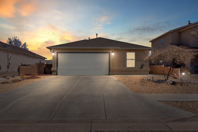 ranch-style home featuring a garage, driveway, fence, and stucco siding