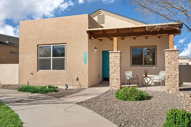 pueblo revival-style home with stucco siding