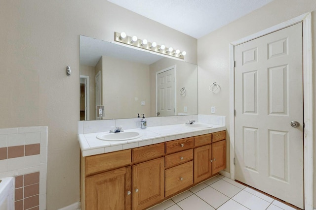 bathroom with a washtub, tile patterned floors, a sink, and double vanity