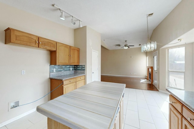 kitchen with ceiling fan, visible vents, open floor plan, tasteful backsplash, and decorative light fixtures