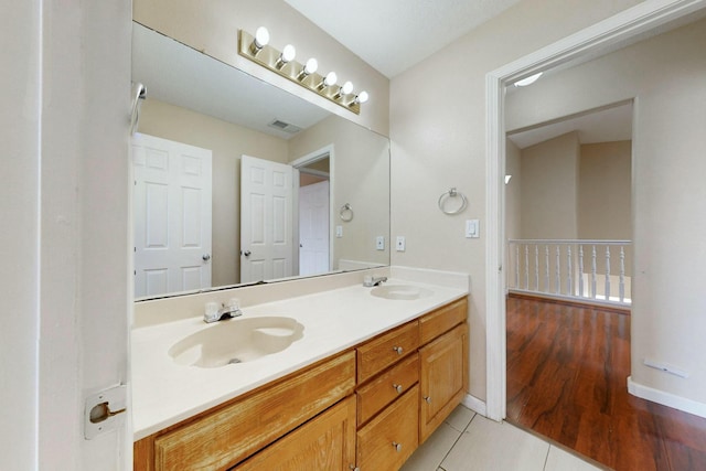 bathroom with double vanity, visible vents, a sink, and tile patterned floors