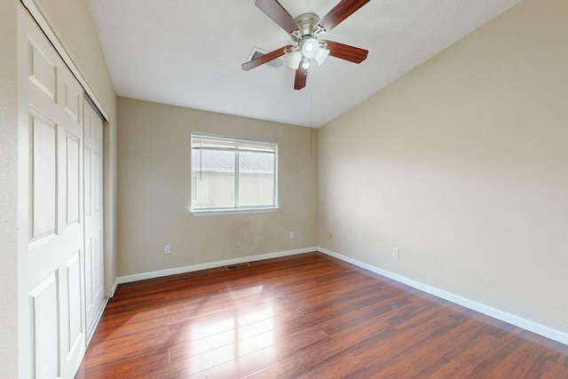 unfurnished bedroom featuring a closet, visible vents, baseboards, and wood finished floors