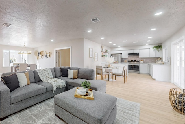 living room featuring recessed lighting, visible vents, and light wood-style flooring