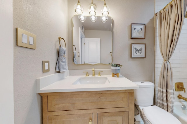 bathroom with visible vents, toilet, vanity, and a textured wall