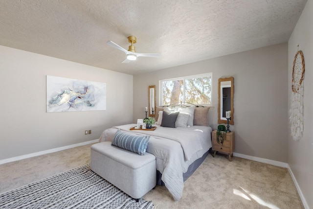 bedroom featuring light colored carpet, a textured ceiling, a ceiling fan, and baseboards