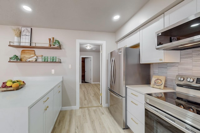 kitchen with white cabinetry, light countertops, backsplash, and appliances with stainless steel finishes