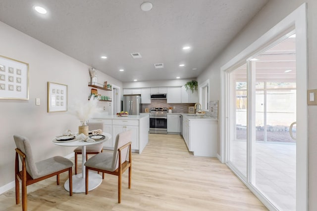 dining area featuring recessed lighting, visible vents, baseboards, and light wood finished floors