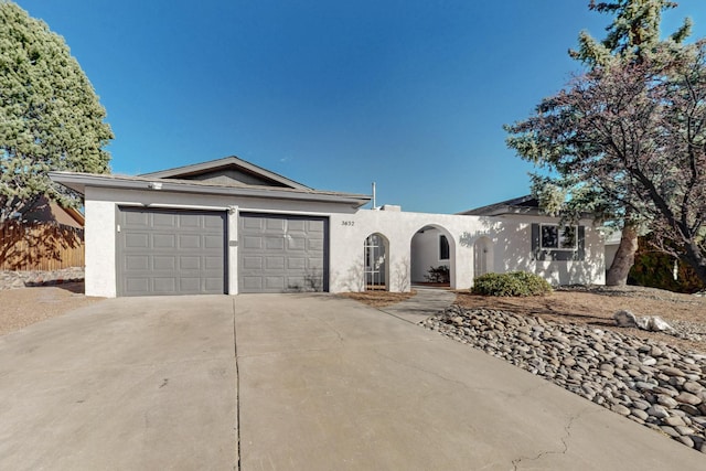 ranch-style house with stucco siding, concrete driveway, and an attached garage