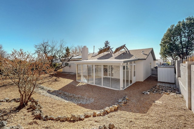 rear view of property featuring stucco siding, a patio, a chimney, and a fenced backyard