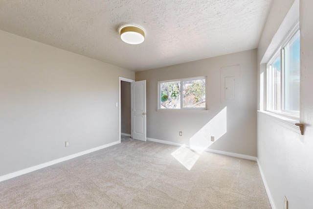 empty room with baseboards, carpet floors, and a textured ceiling