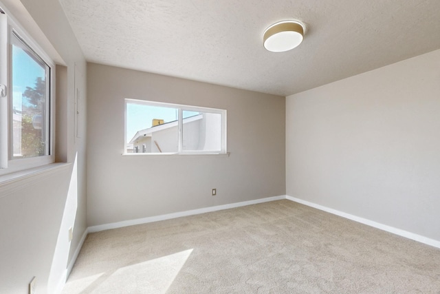 spare room featuring a textured ceiling, baseboards, and carpet floors