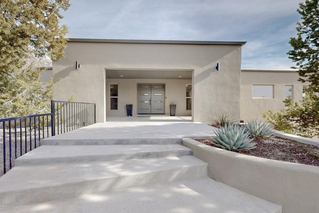 doorway to property featuring french doors and stucco siding