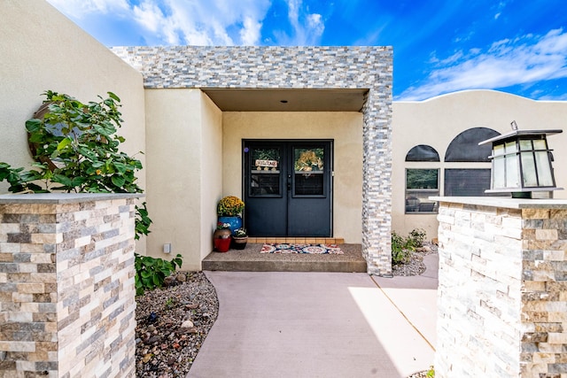 property entrance with french doors and stucco siding