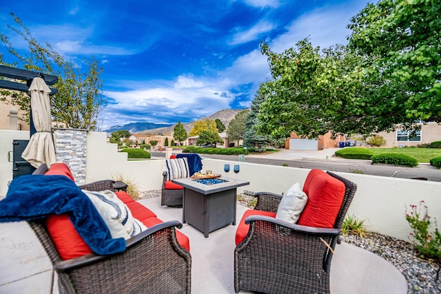 view of patio featuring an outdoor living space with a fire pit and a mountain view