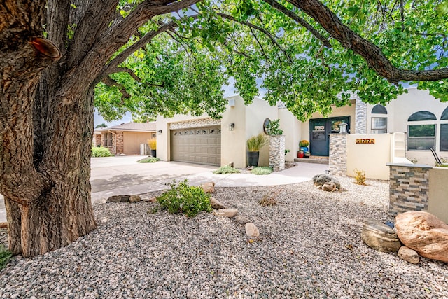 view of front of house with driveway, a garage, and stucco siding