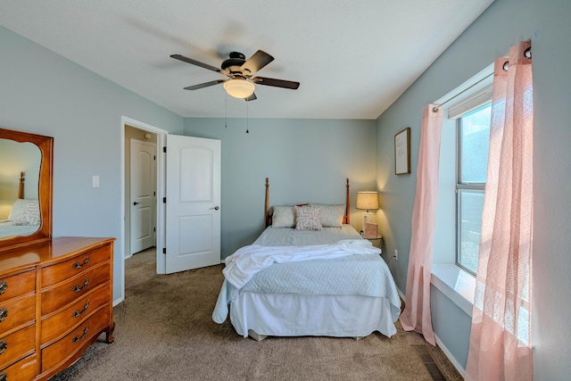 carpeted bedroom with visible vents, baseboards, and a ceiling fan