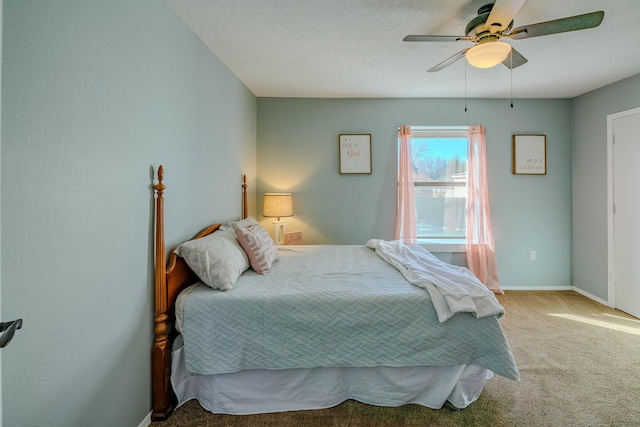 carpeted bedroom with ceiling fan, baseboards, and a textured ceiling