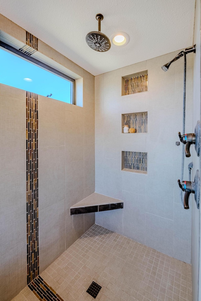 full bath with tiled shower and a textured ceiling