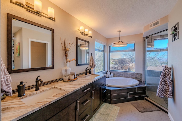 bathroom featuring tile patterned flooring, visible vents, a sink, and a textured ceiling