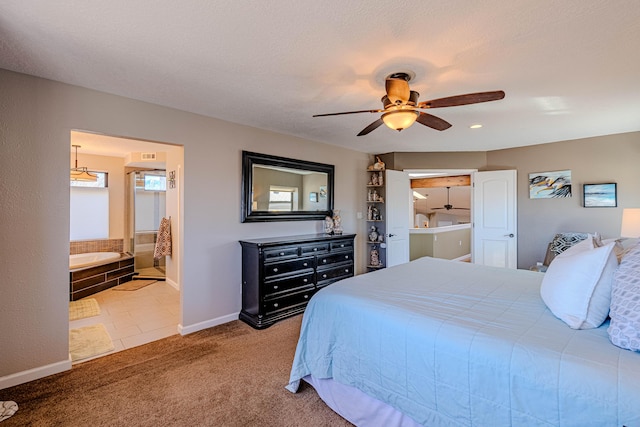 carpeted bedroom featuring ceiling fan, a textured ceiling, baseboards, and ensuite bathroom