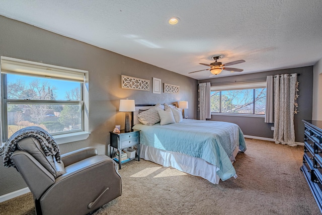 bedroom with a textured ceiling, ceiling fan, carpet flooring, and baseboards