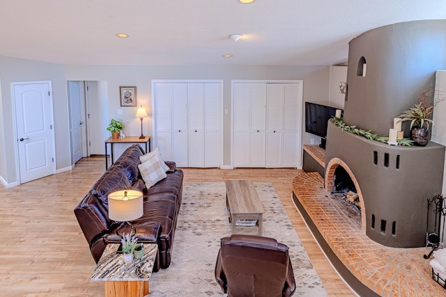 living area featuring light wood finished floors, baseboards, and recessed lighting