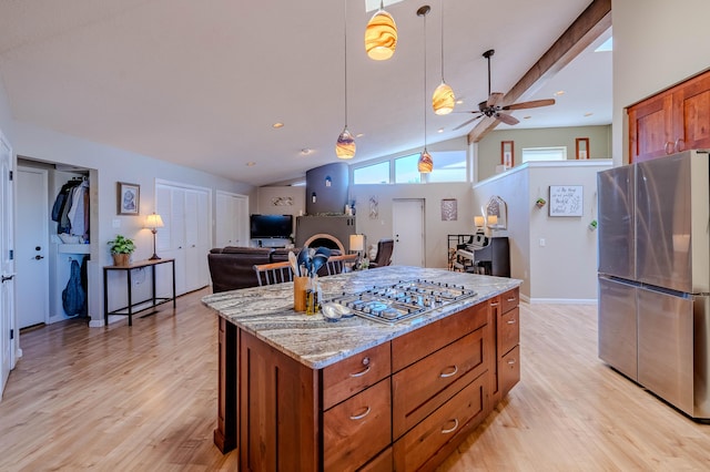 kitchen featuring vaulted ceiling with beams, light wood-style flooring, hanging light fixtures, appliances with stainless steel finishes, and brown cabinets