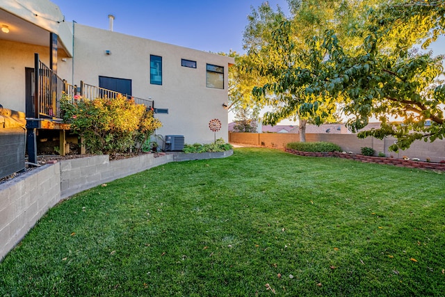 view of yard with central AC unit and fence