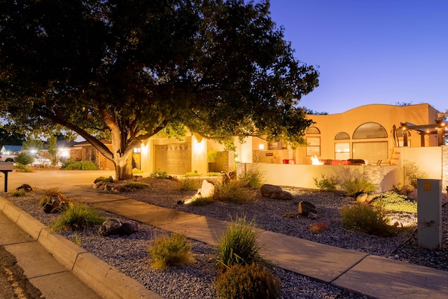 view of front of home with a garage and stucco siding