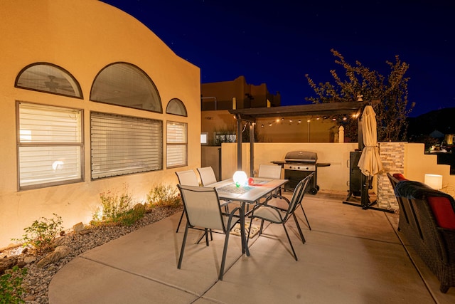 patio at night with a grill and outdoor dining space