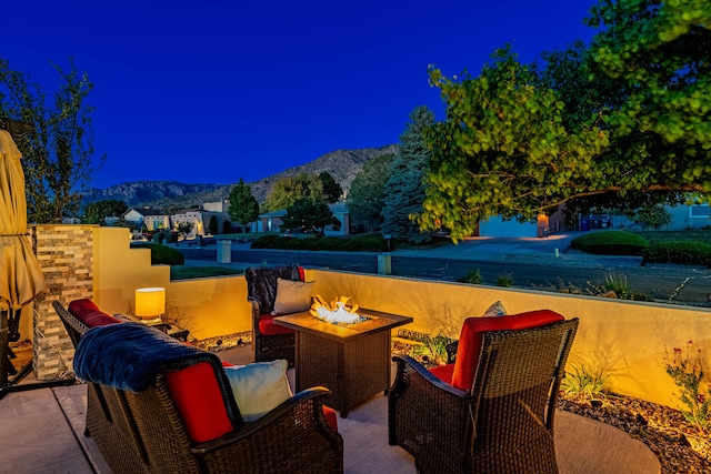 view of patio featuring an outdoor fire pit and a mountain view