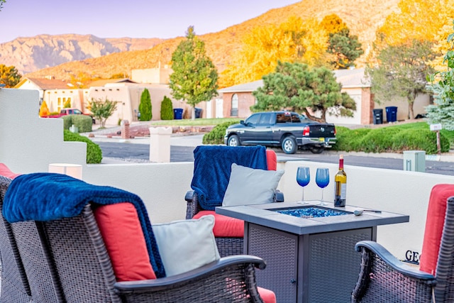 view of patio featuring an outdoor fire pit and a mountain view