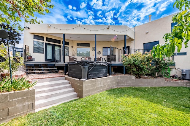 rear view of property featuring central AC, a lawn, and stucco siding