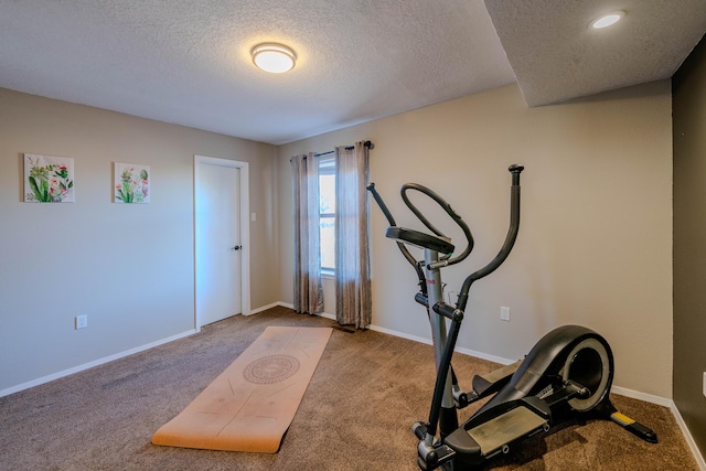 exercise room featuring carpet, baseboards, and a textured ceiling