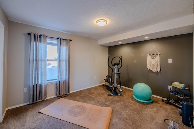 workout room featuring carpet floors, baseboards, and a textured ceiling