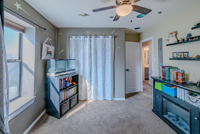 recreation room with carpet floors, baseboards, and a ceiling fan