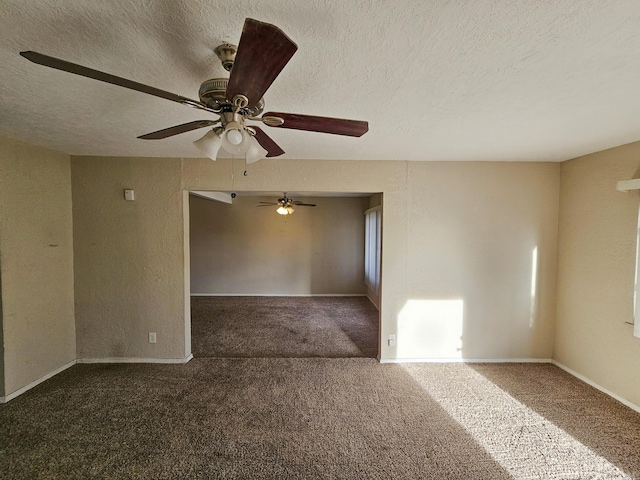 carpeted spare room featuring a textured ceiling and baseboards