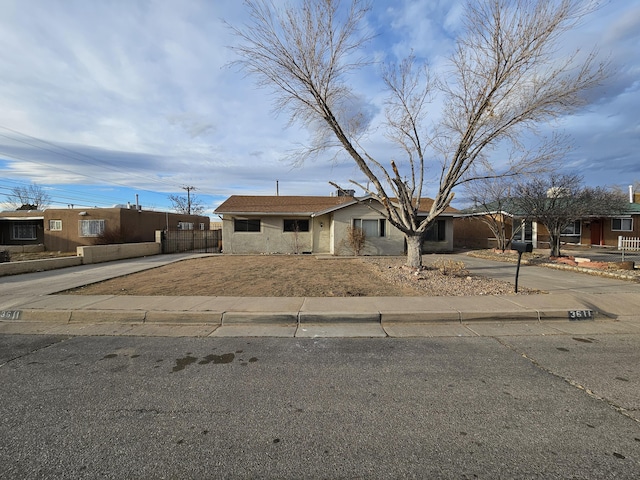 view of front of home with concrete driveway and fence