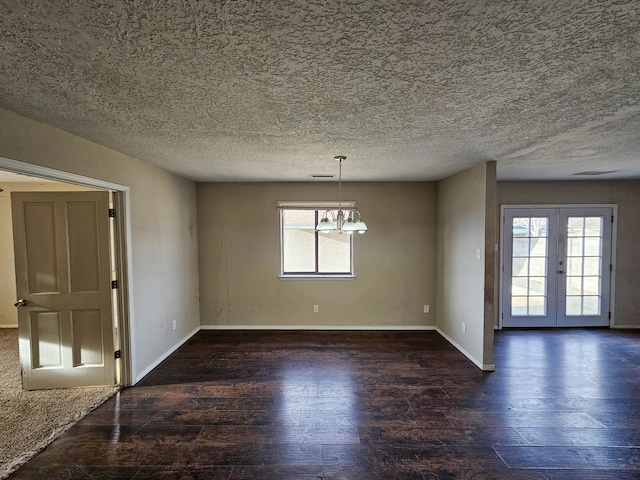 spare room featuring a healthy amount of sunlight, french doors, and wood finished floors