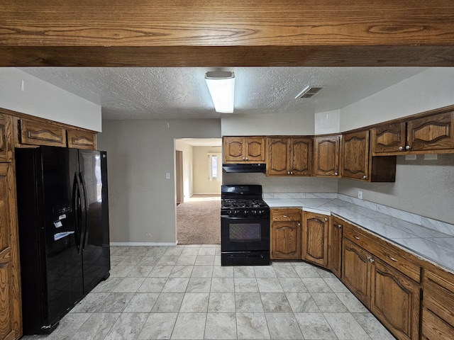 kitchen with visible vents, black appliances, under cabinet range hood, a textured ceiling, and tile counters