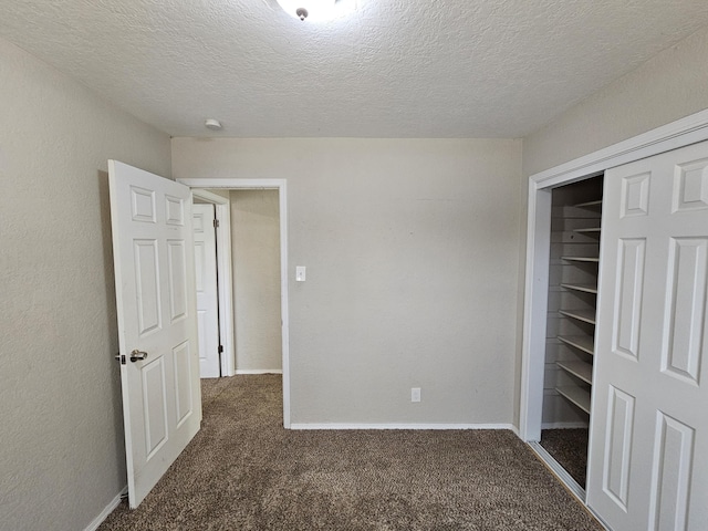 unfurnished bedroom with baseboards, carpet floors, and a textured ceiling