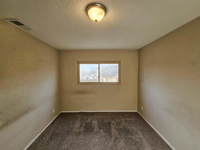 carpeted empty room with visible vents, baseboards, and a textured ceiling