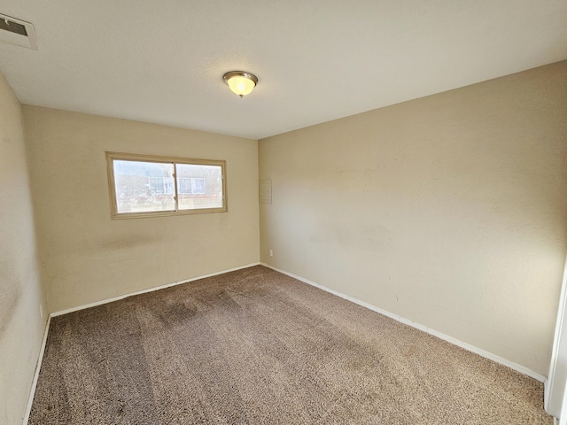 empty room featuring visible vents, baseboards, and carpet floors