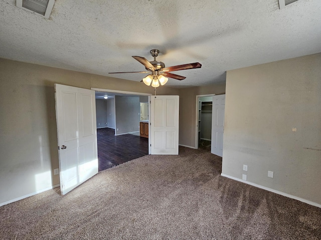 unfurnished bedroom with a ceiling fan, carpet, visible vents, baseboards, and a textured ceiling